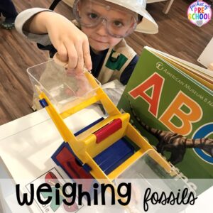 Weighing the fossils! ow to make a Dinosaur Dig Site in dramatic play and embed tons of math, literacy, and STEM into their play. Perfect for preschool, pre-k, and kindergarten. #preschool #prek #dinosaurtheme #dinodig #dramaticplay